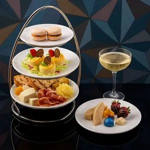A 3 tiered serving tray and a separate platter filled with small appetizers and pastries and 2 coupes of sparkling wine