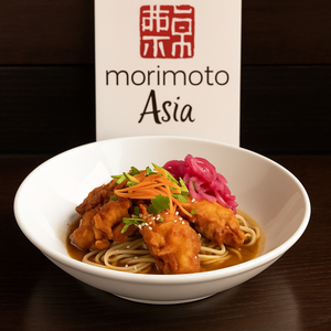 Mãe e  crianças sorriem enquanto saboreiam seus pratos em um moderno salão de jantar no Morimoto Asia