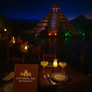 Close-up of tables near trees and Mayan pyramid with volcano in background